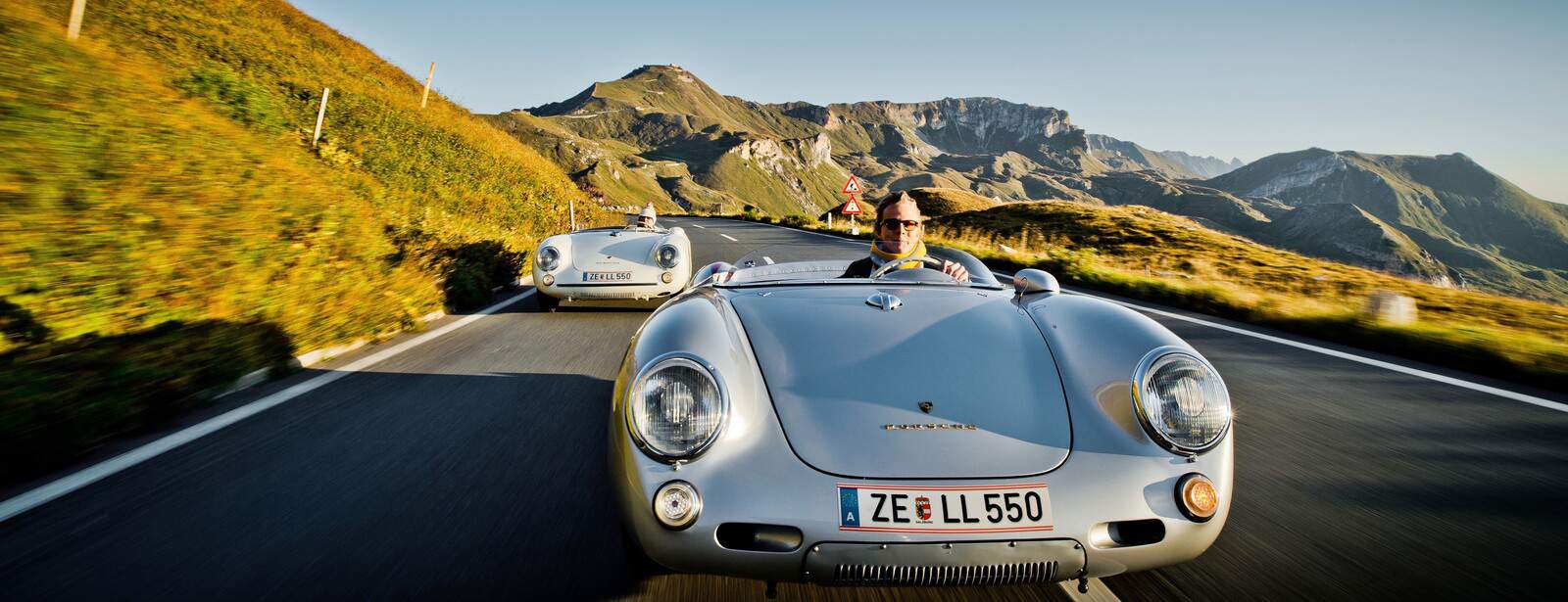 Ferdinand Porsche im historischen Fahrzeug beim Pass-Fahren